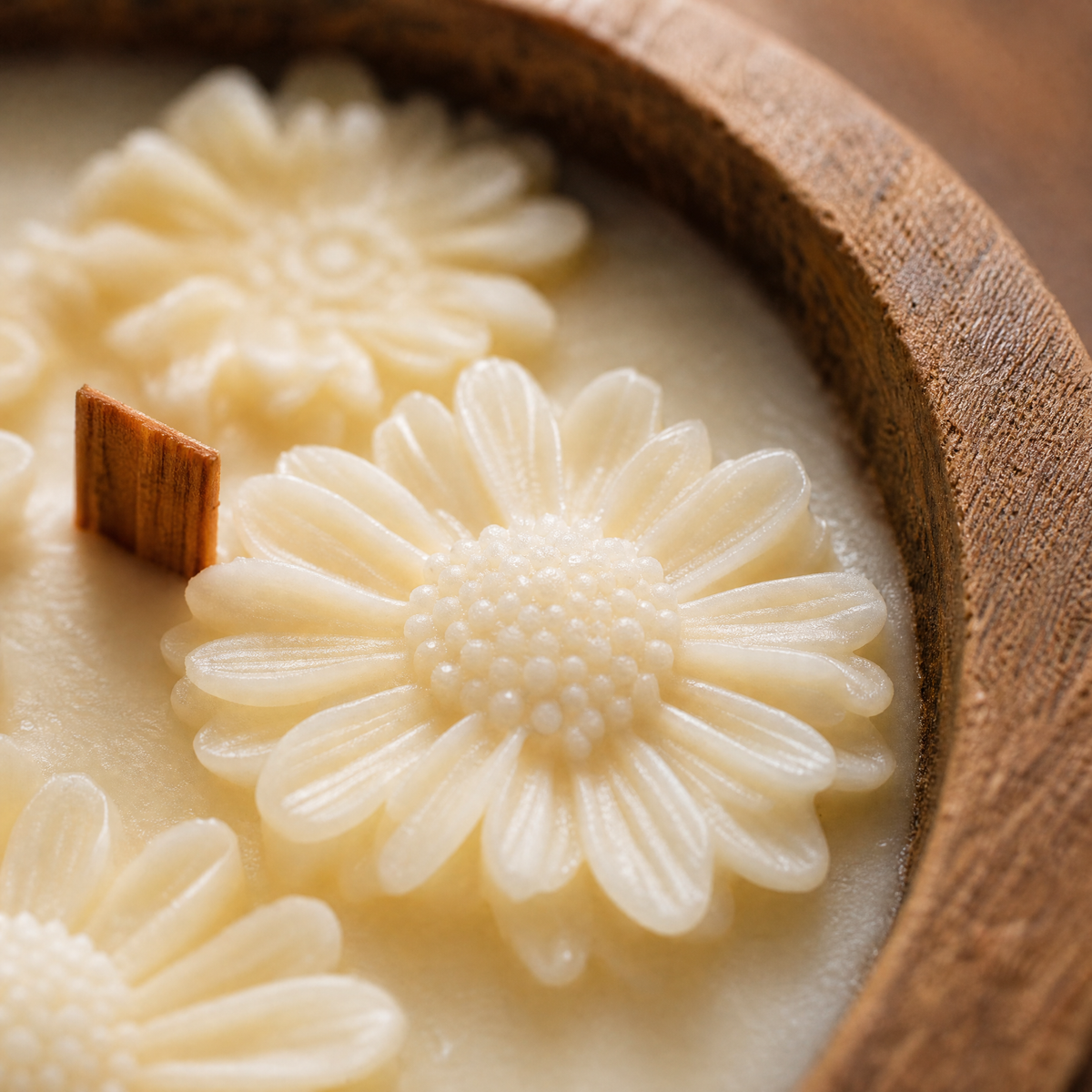 Close up of sculpted wax daisy and wood wick